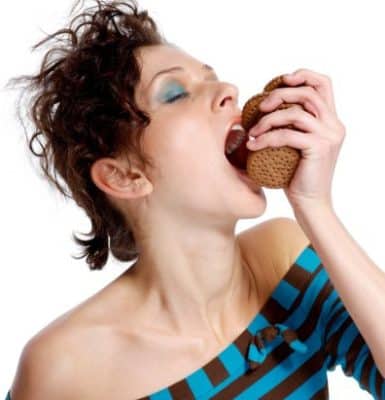 Greedy woman eating biscuits